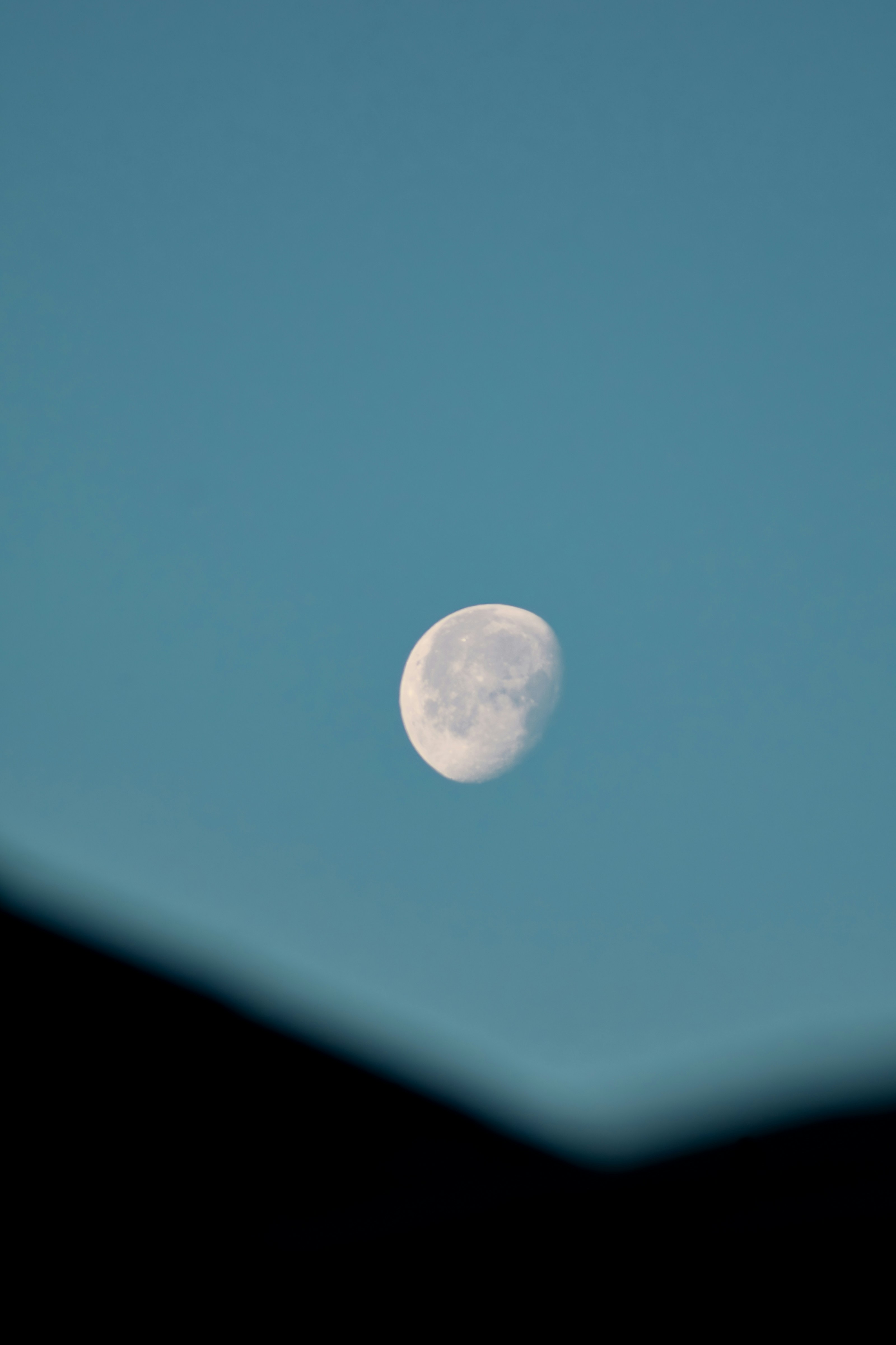 A full moon is seen in the blue sky