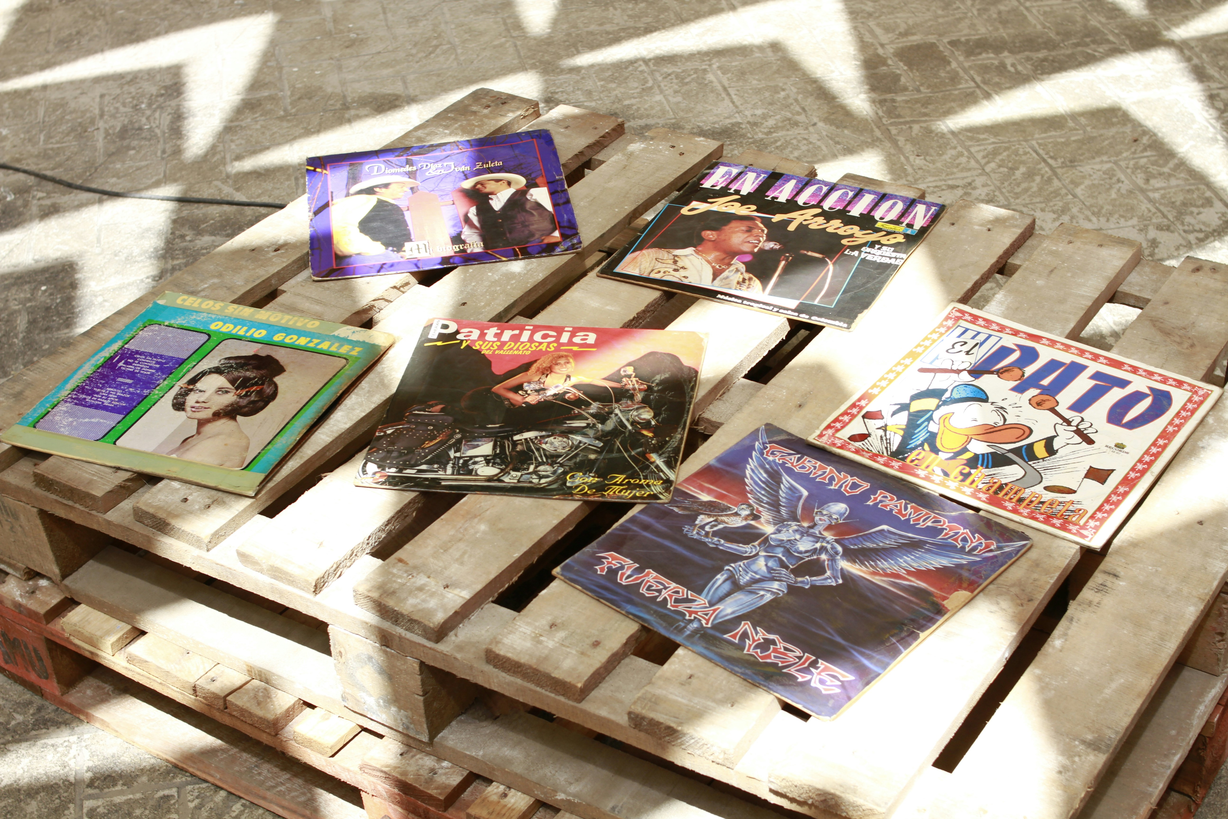 A wooden crate filled with books on top of a tiled floor
