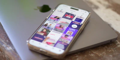 A cell phone sitting on top of a laptop computer