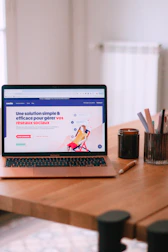A laptop computer sitting on top of a wooden table