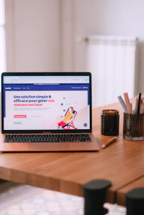 A laptop computer sitting on top of a wooden table