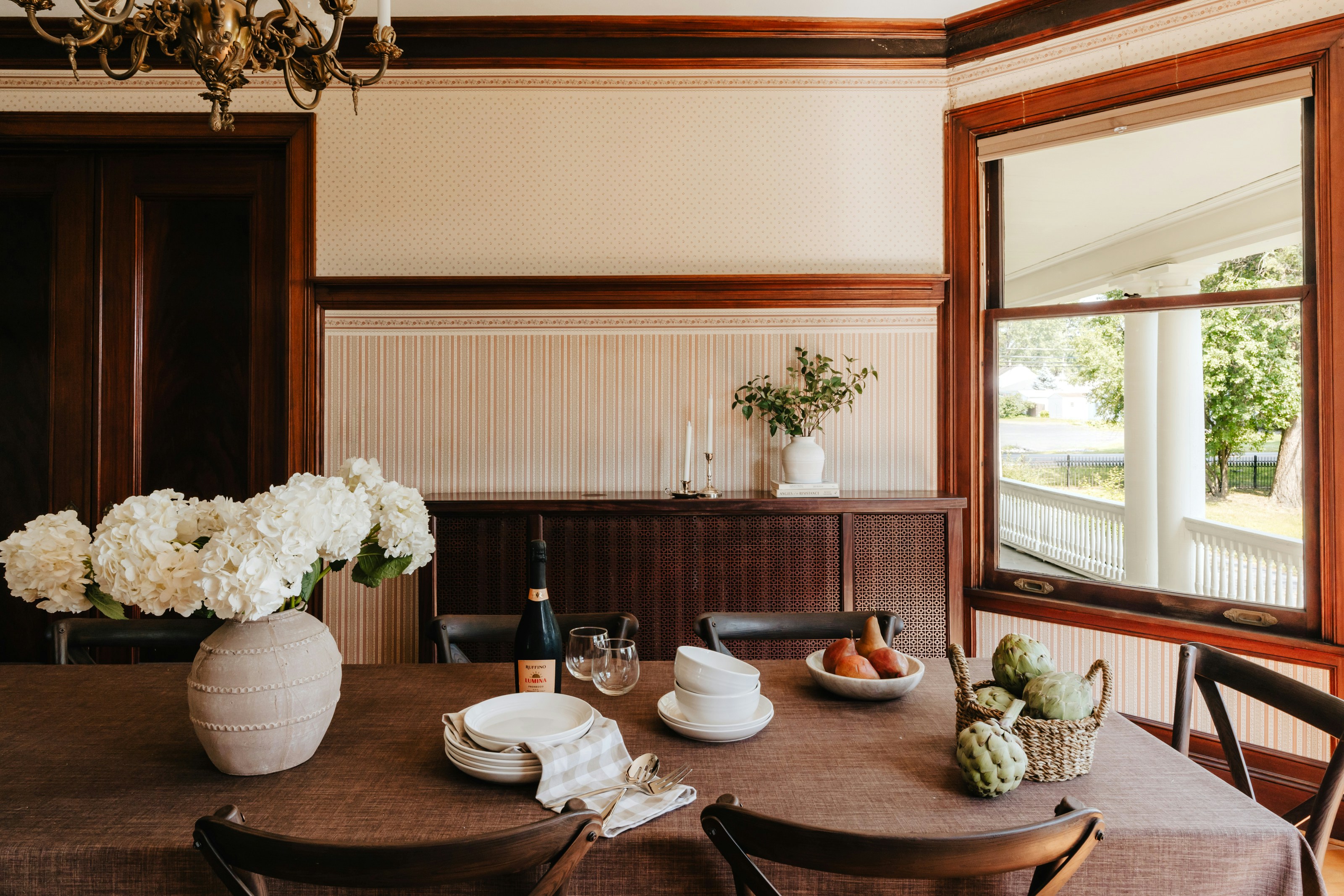 A dining room table with a vase of flowers on it