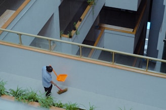 A man with a broom is sweeping the street