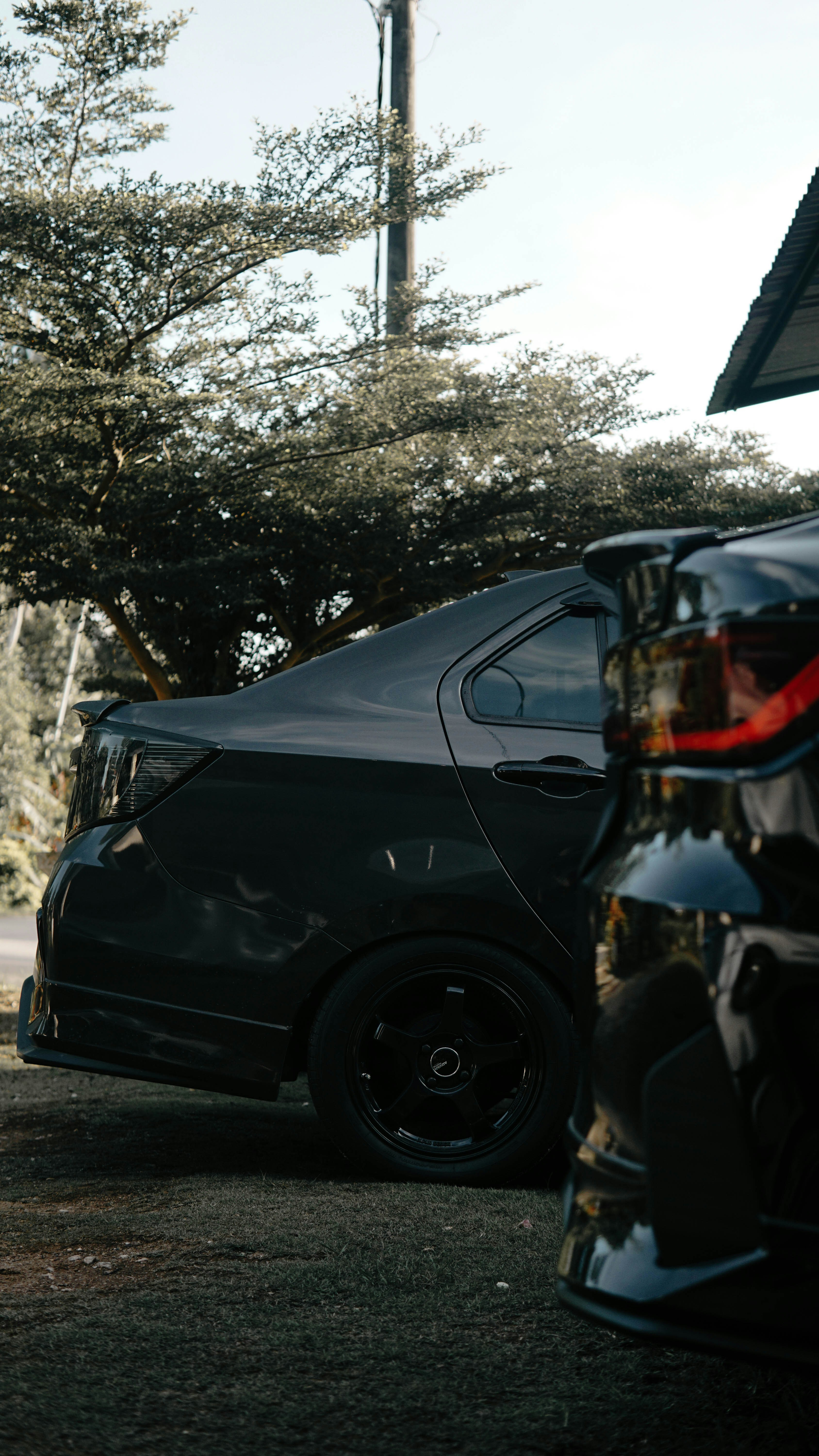 A man riding a skateboard next to a parked car
