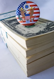 A button on top of a stack of money