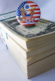 A button on top of a stack of money