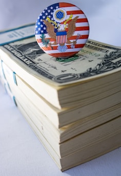 A button on top of a stack of money