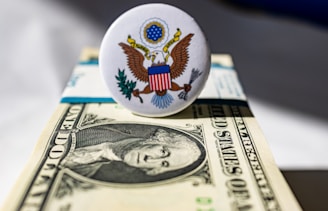 A white button sitting on top of a one dollar bill