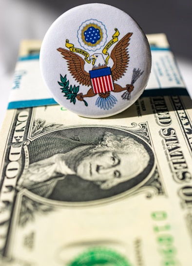 A close up of a button on top of a one dollar bill