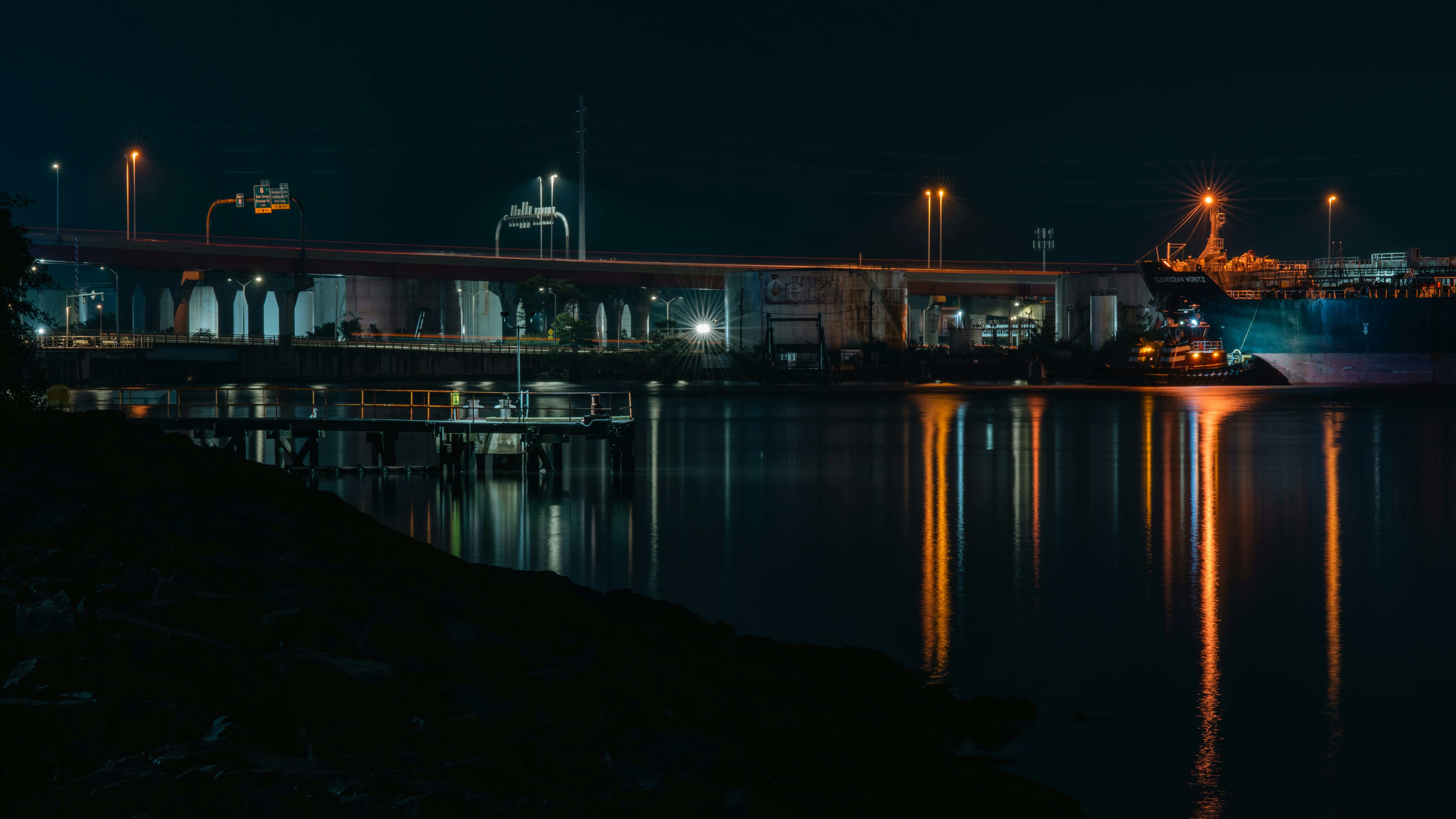 A large body of water with a bridge in the background