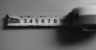 A measuring tape is on a wooden surface