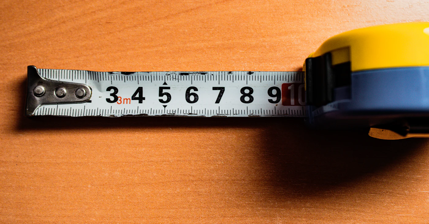 Tape measure resting on a wooden table, ready for body measurement