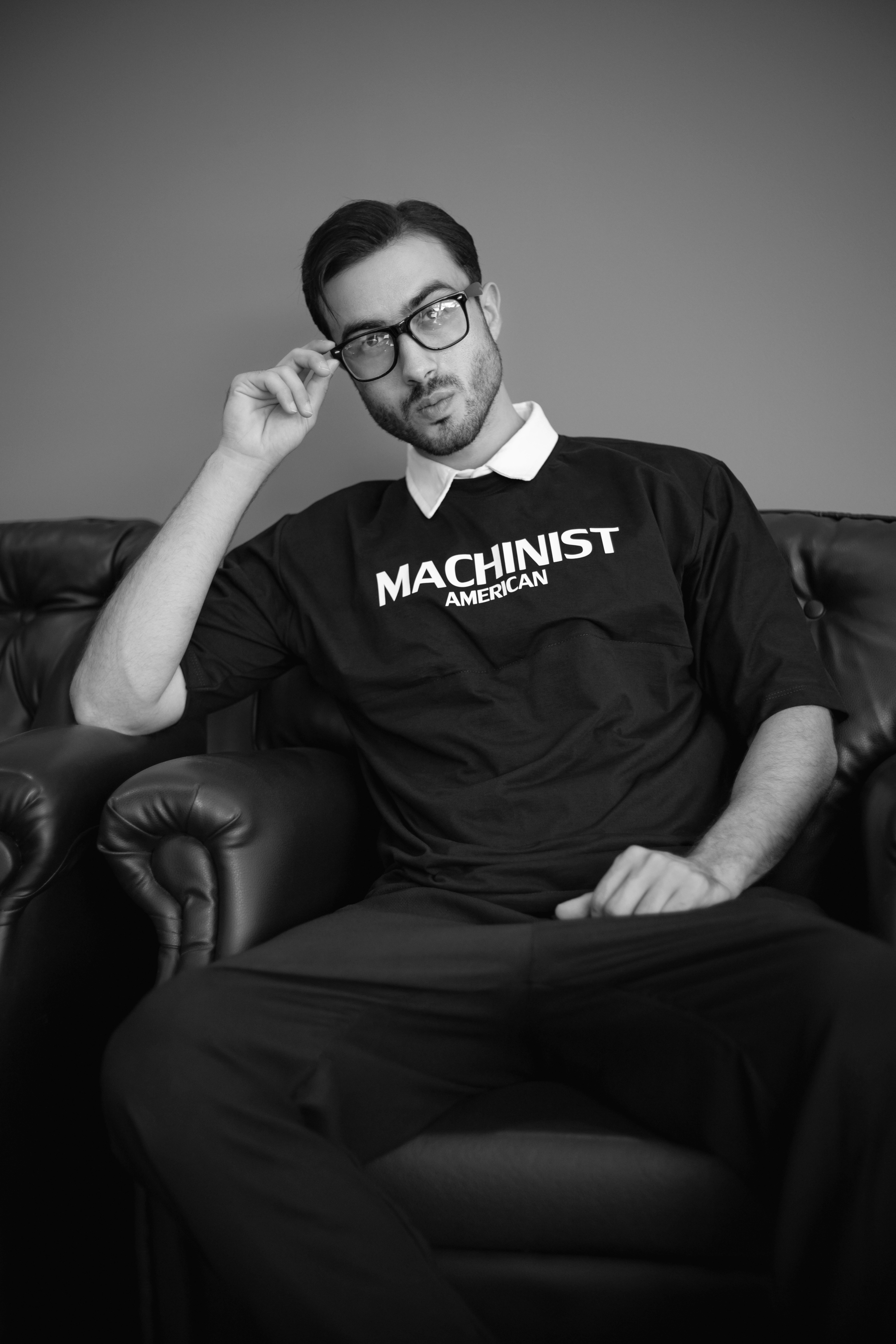 A man sitting in a chair with his hand on his head