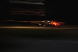 A blurry photo of a car driving at night