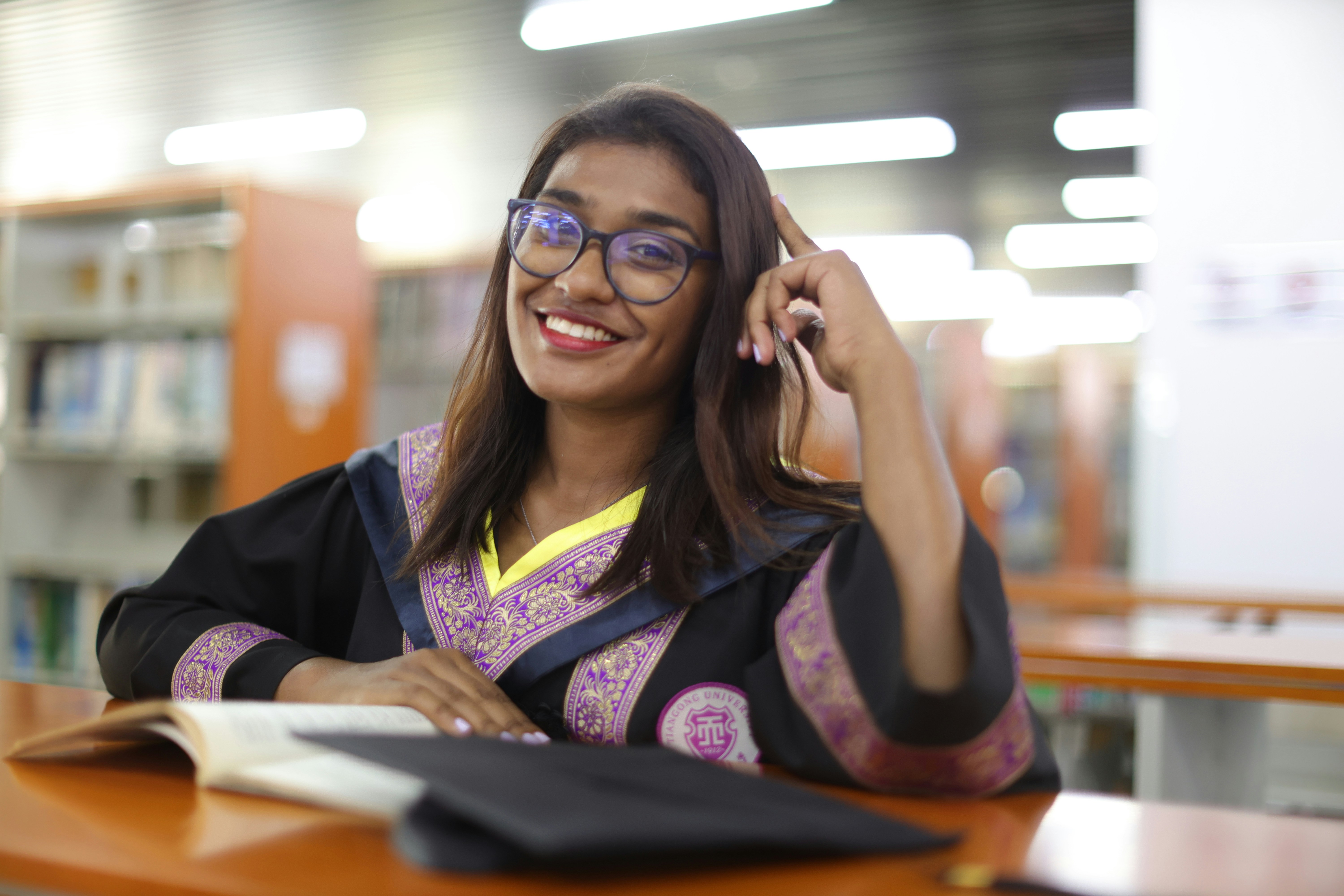 A woman sitting at a desk talking on a cell phone