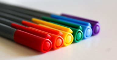 A row of colored pencils sitting on top of a white table