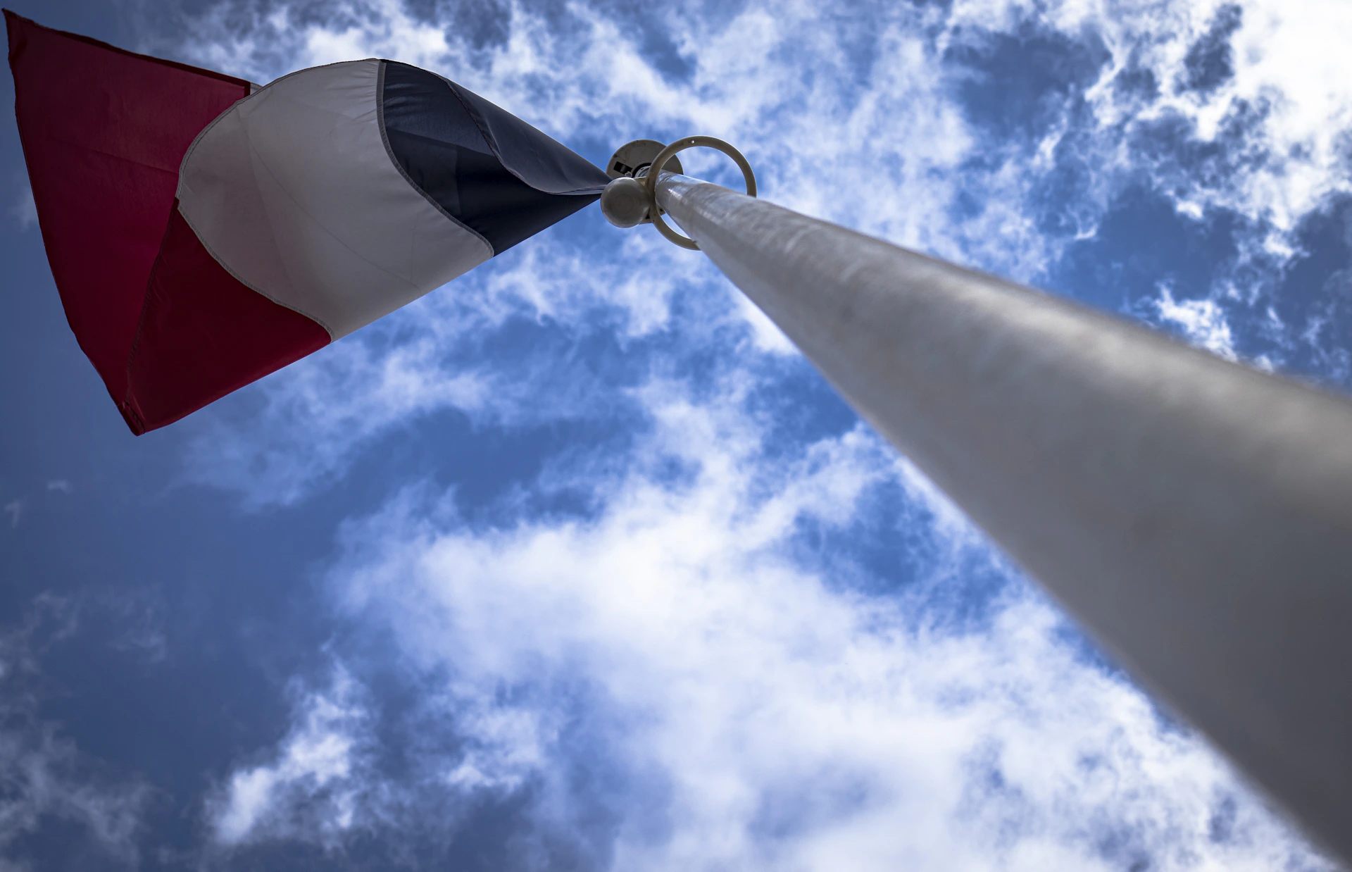 A red, white and black flag on a pole