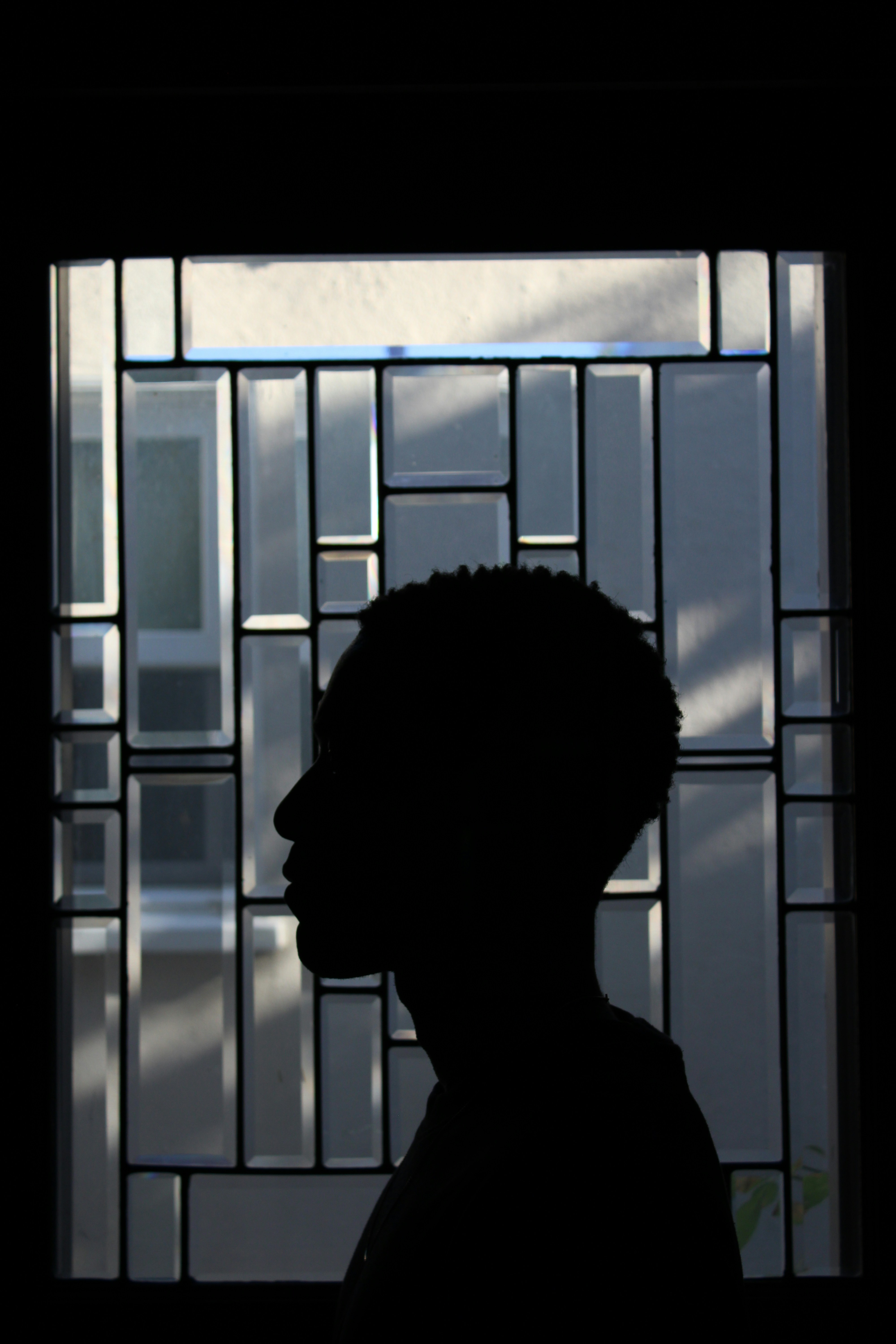 Die Silhouette einer Person, die vor einem Fenster steht
