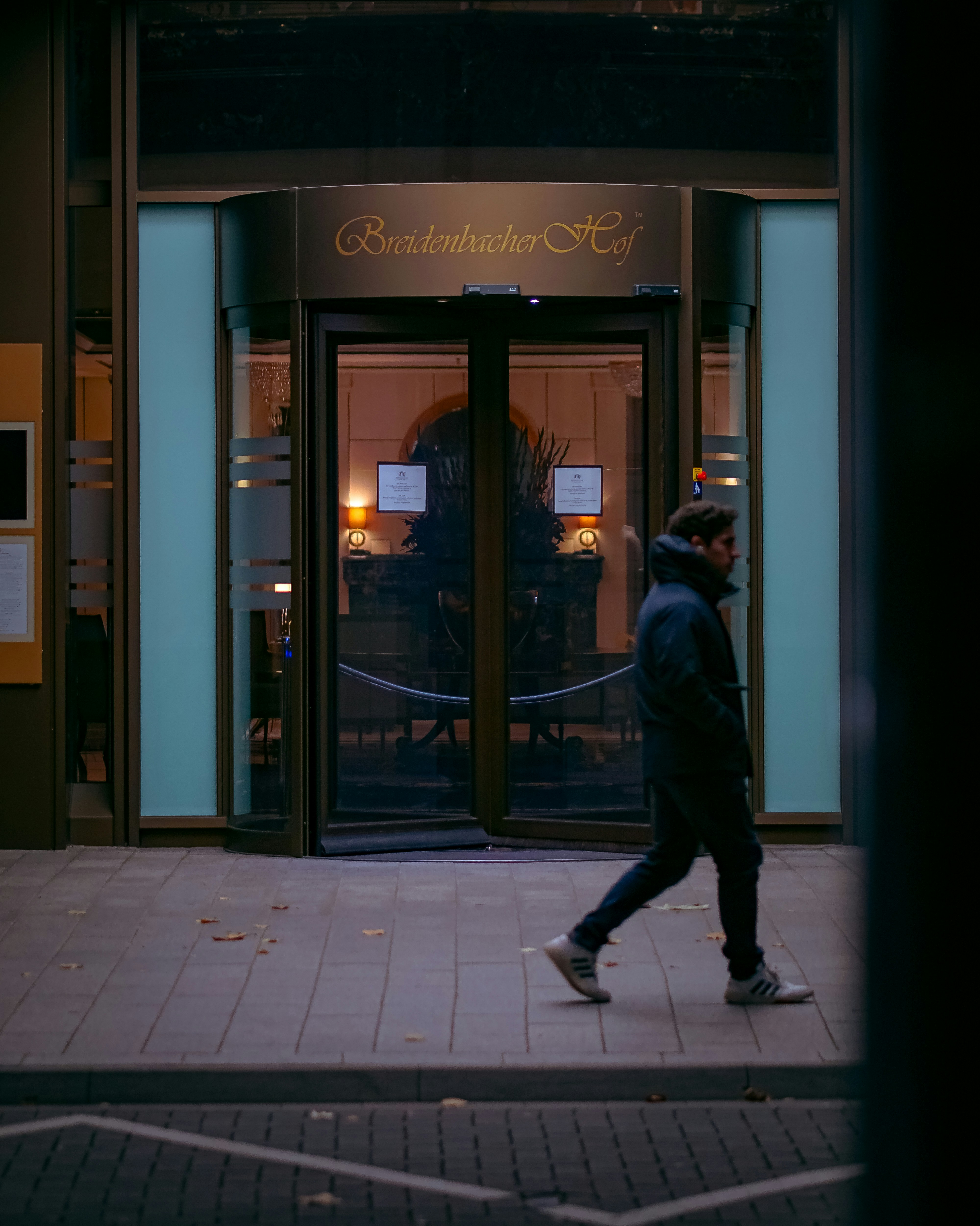 A man walking down a sidewalk in front of a building photo – Free Man ...