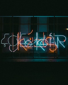A neon sign that is on the side of a building