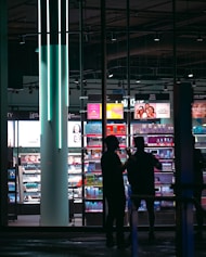A couple of people standing in front of a store