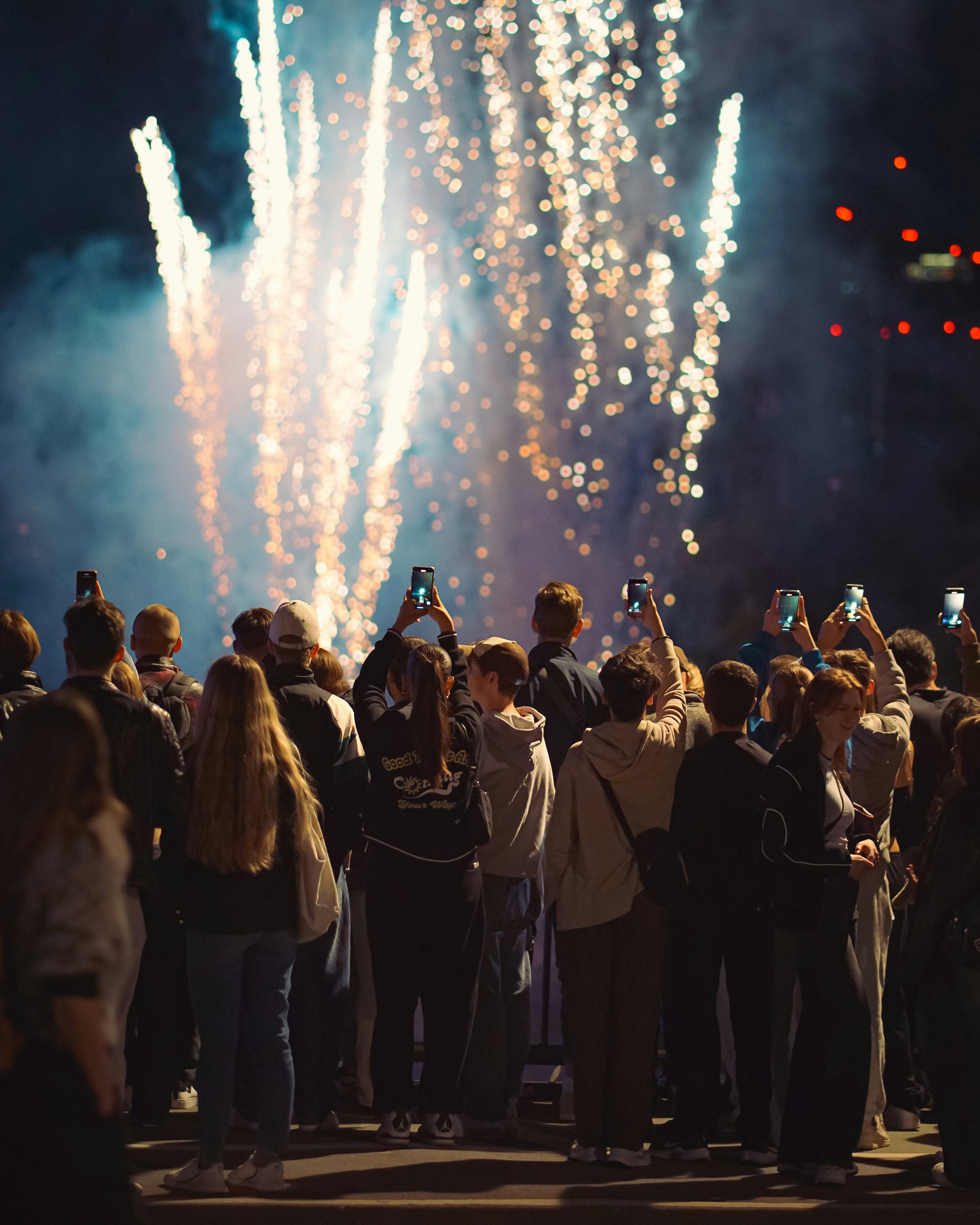 A crowd of people standing around a firework display
