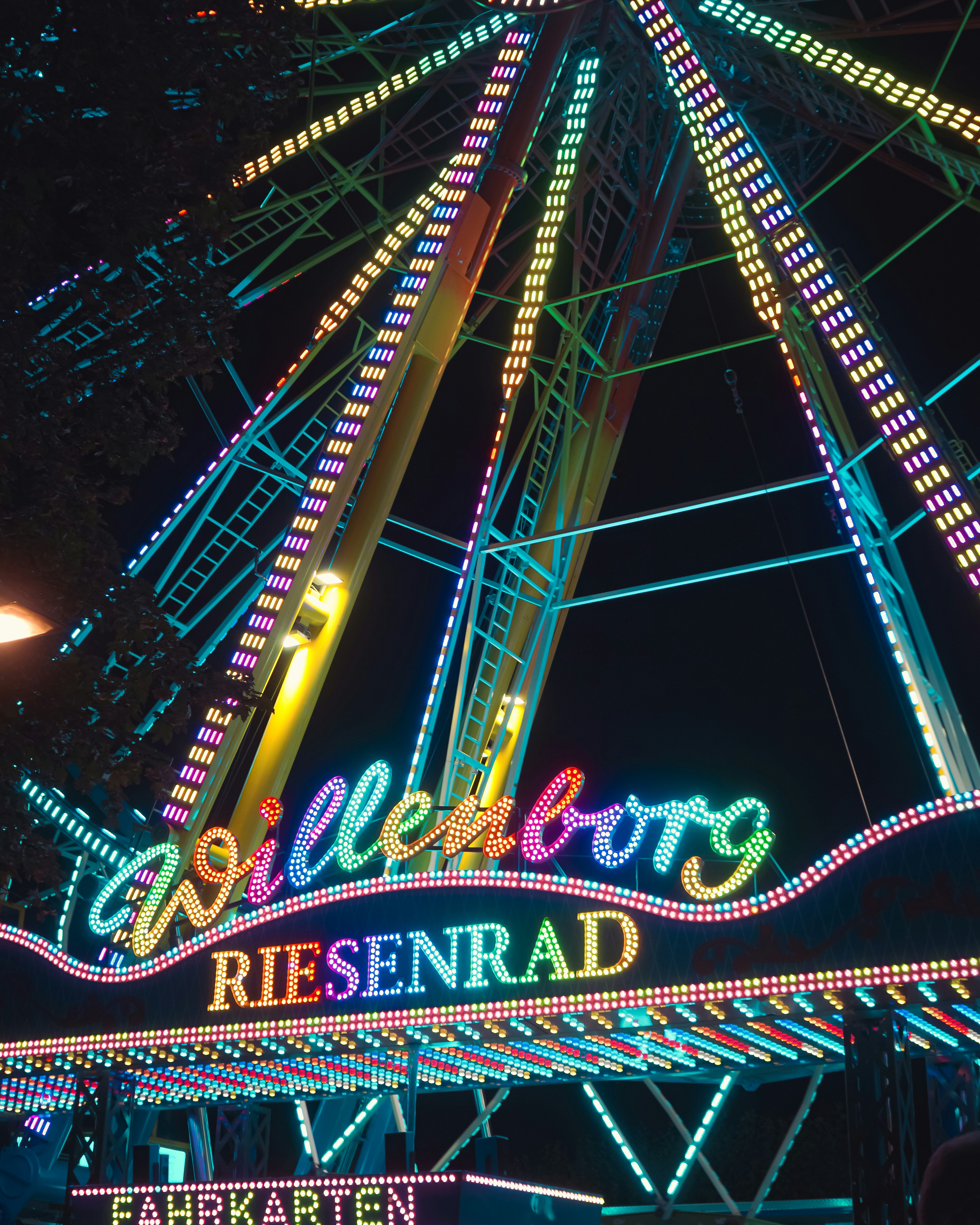 A ferris wheel lit up at night with lights