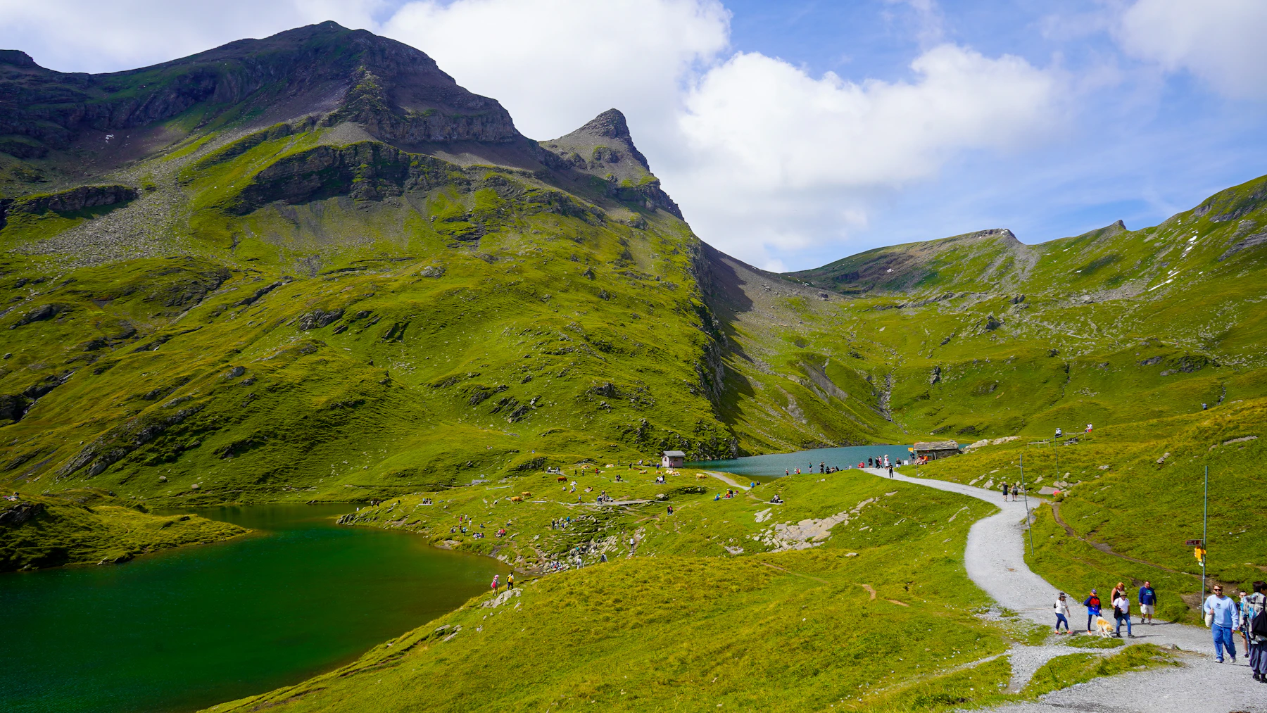 Hikers following a trail above a lake near Interlaken, Switzerland.