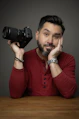 A man sitting at a table with a camera