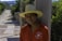 A man wearing a hat leaning against a wall
