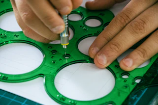 A person is making a hole in a piece of paper