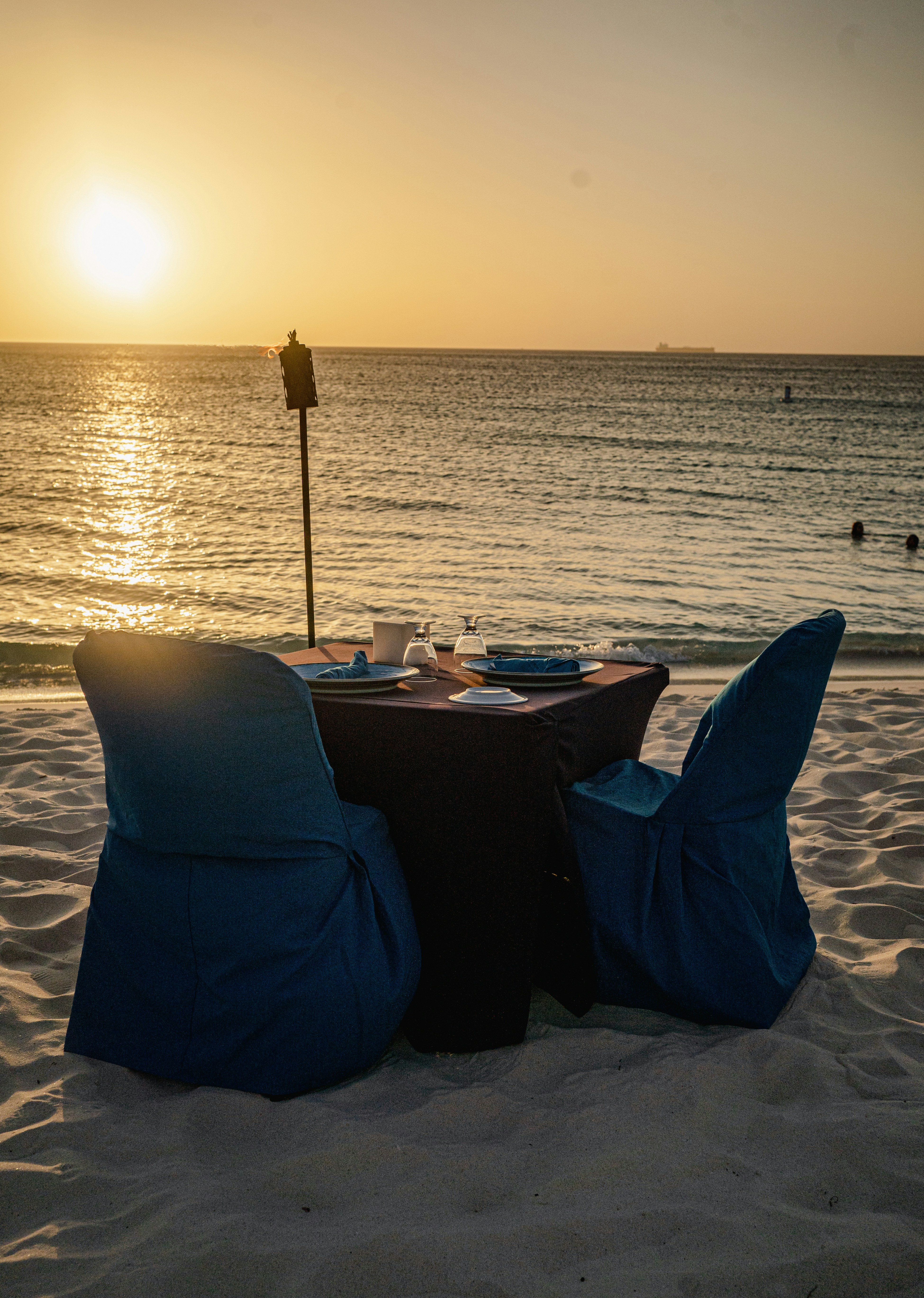 A couple of chairs sitting on top of a sandy beach