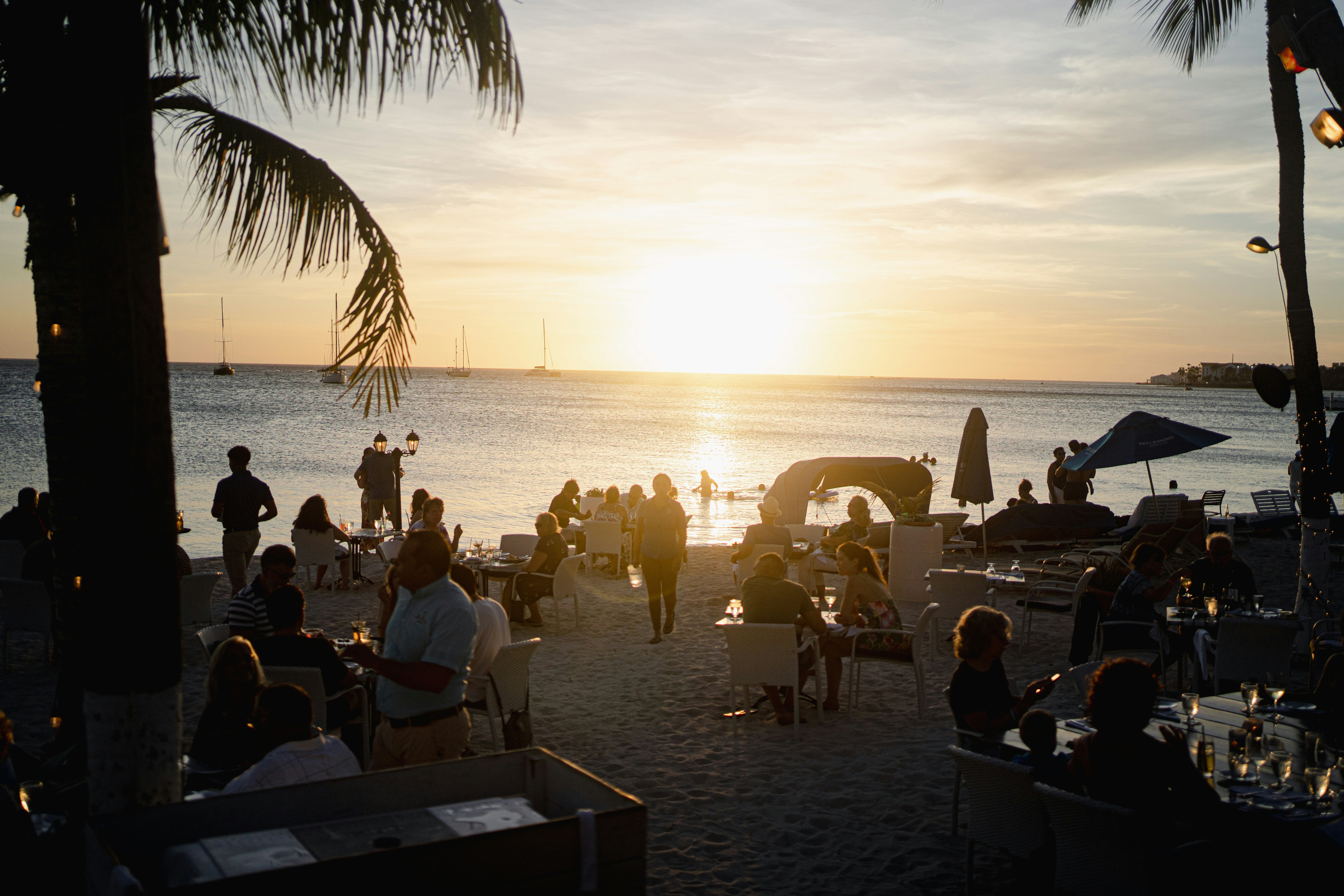 A group of people standing on top of a sandy beach