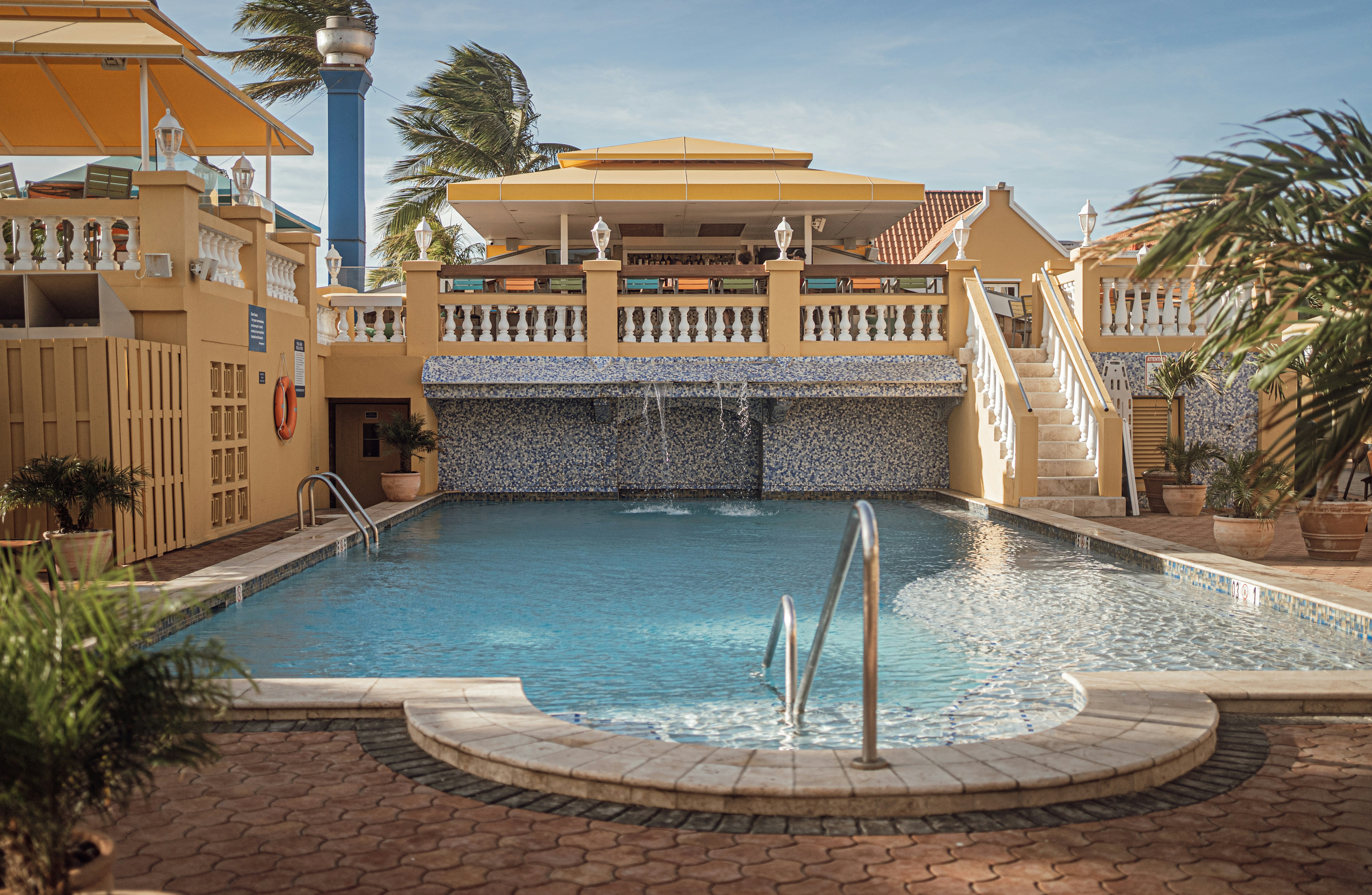 A large swimming pool with a waterfall in the middle of it