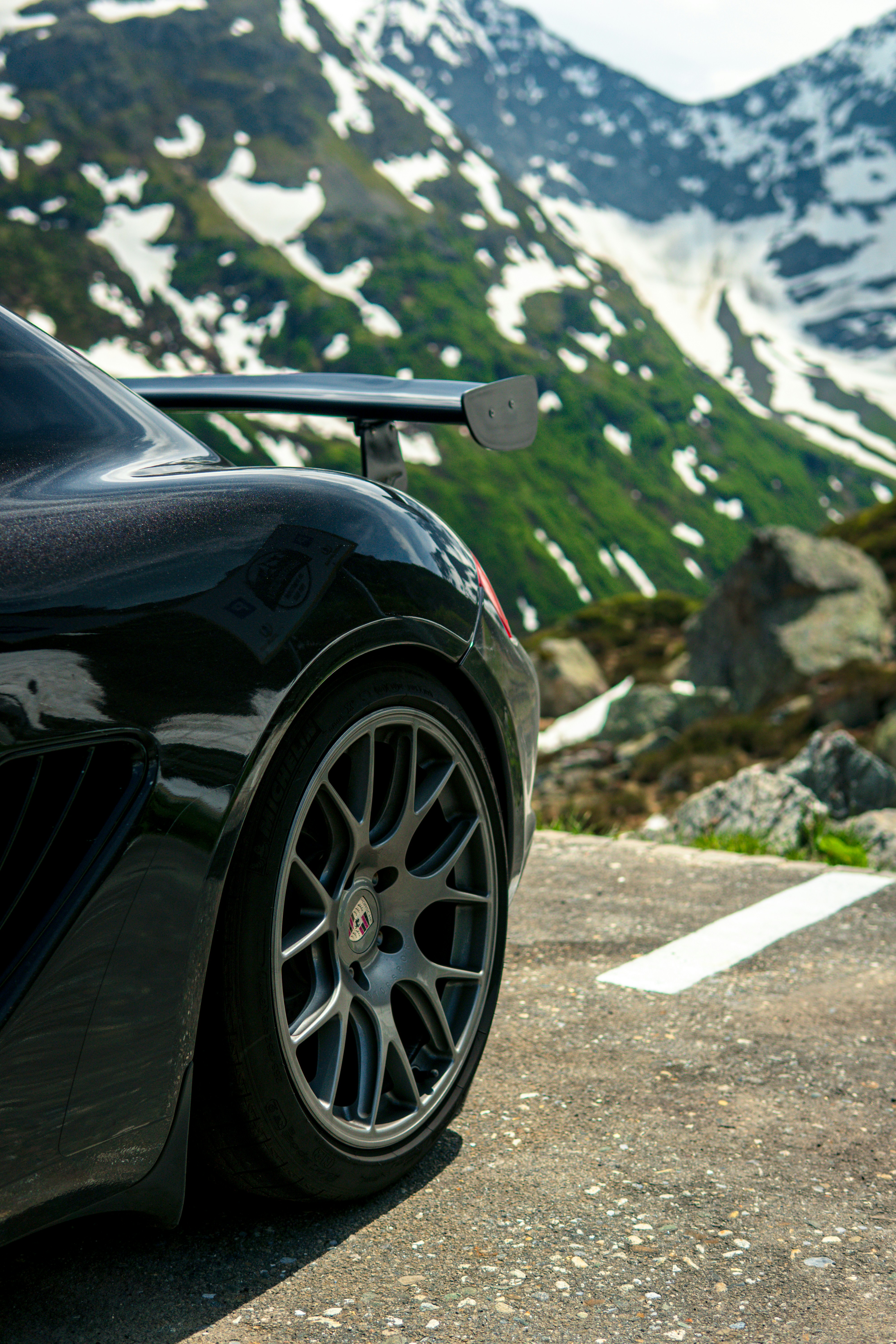 A black sports car parked in front of a mountain