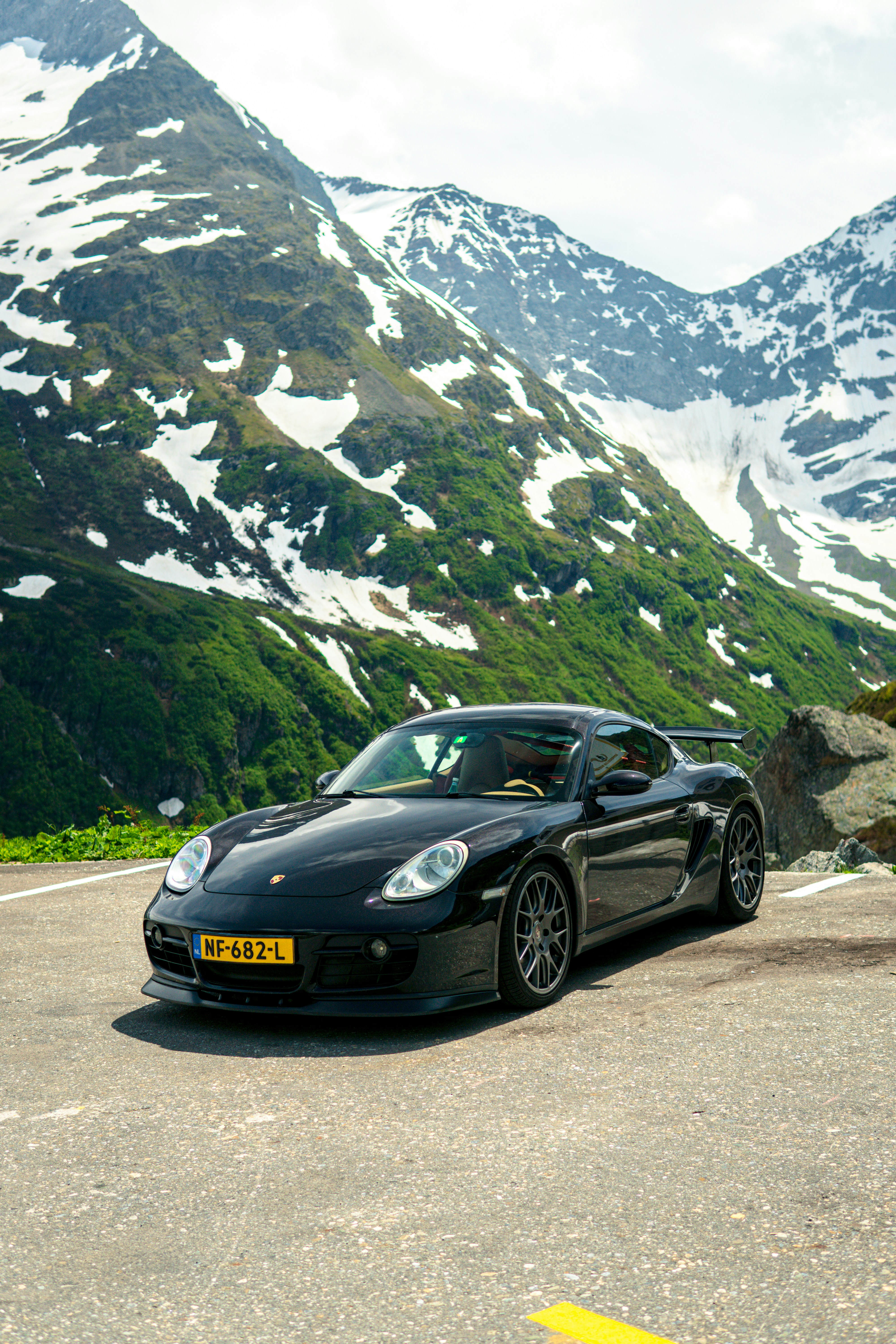 A black sports car parked in front of a mountain