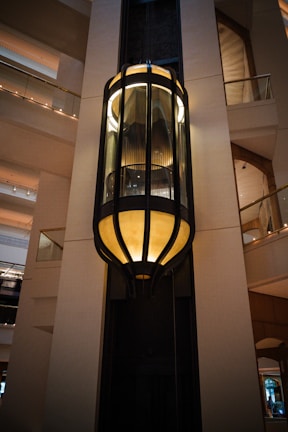 A tall light hanging from the side of a building