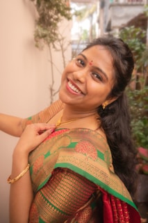 A woman in a sari smiling for the camera