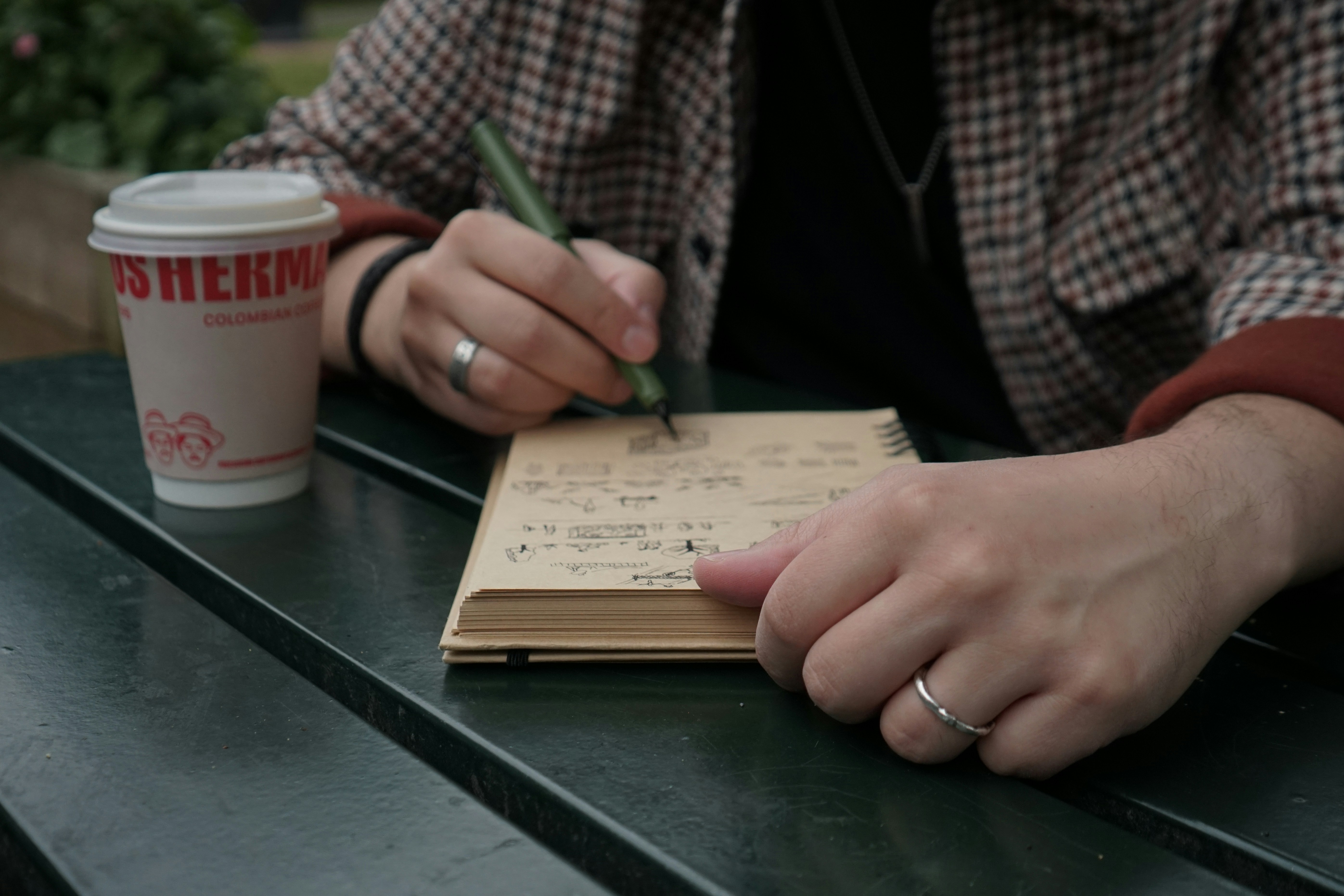 A person sitting at a table writing on a notebook