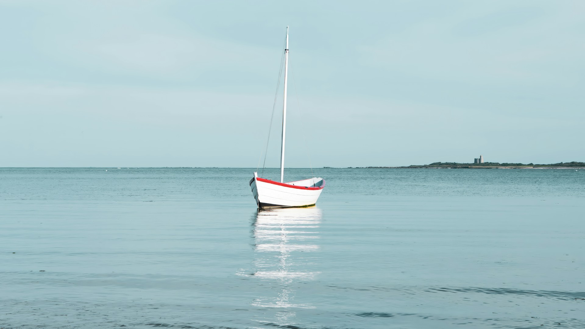 A small boat floating on top of a body of water