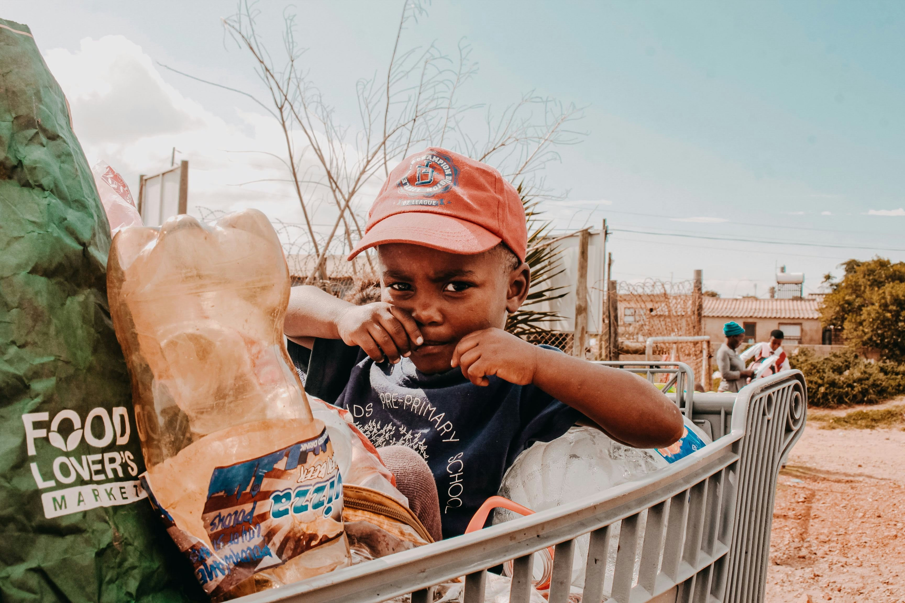 A young boy sitting in a shopping cart
