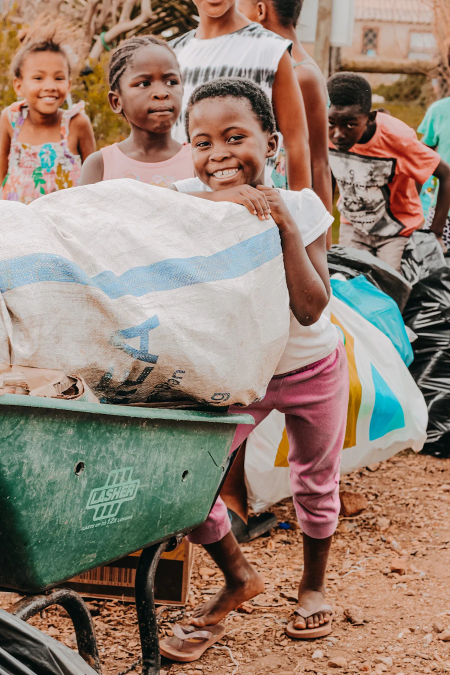 Children gathered around a wheelbarrow