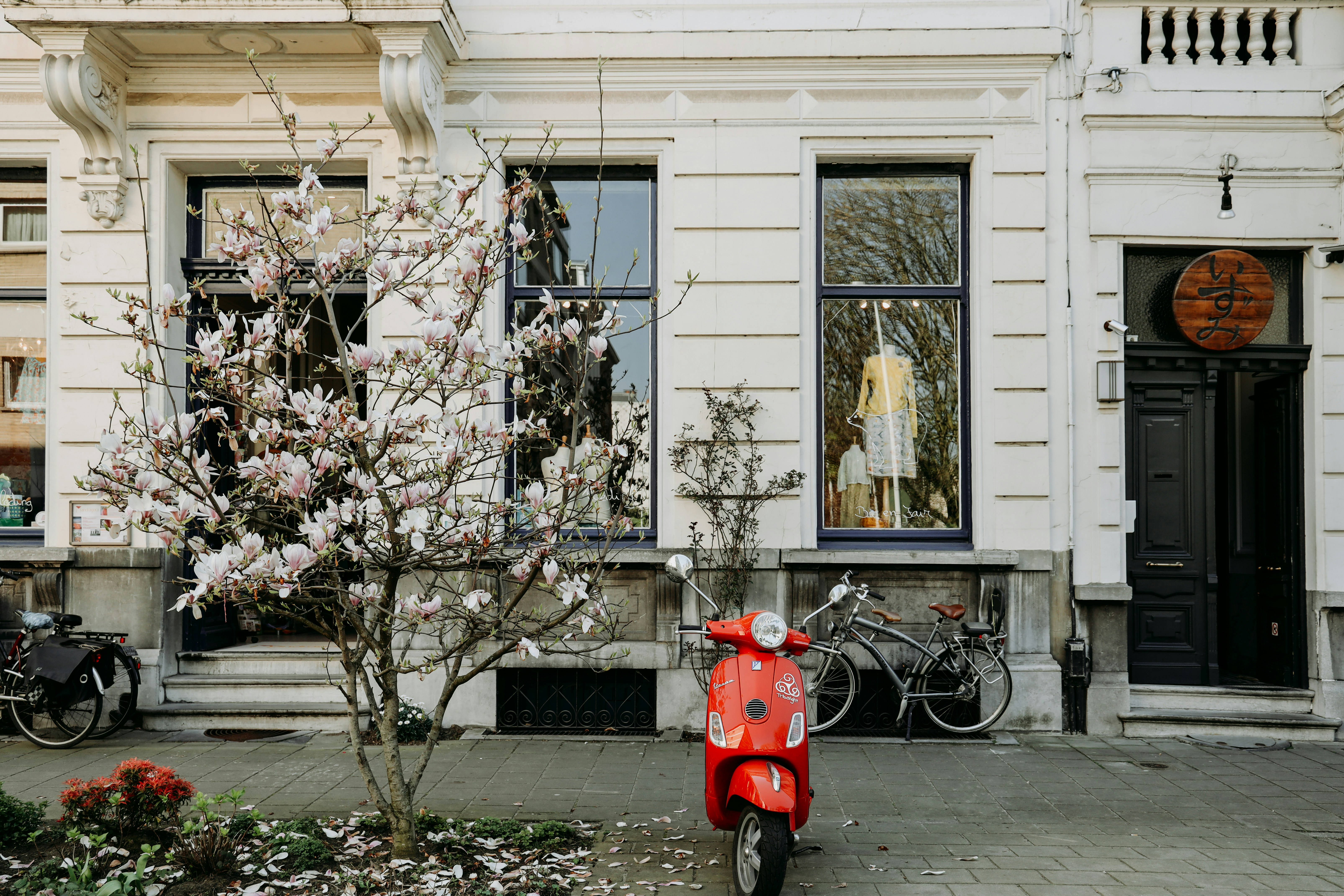 Una boca de incendios roja frente a un edificio blanco