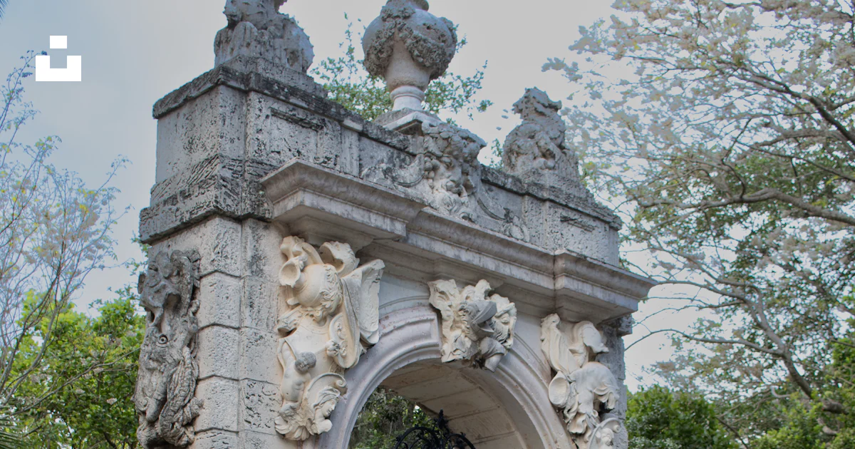 Statues Gates A stone gate with statues on top of it photo – Free Miami Image on Unsplash