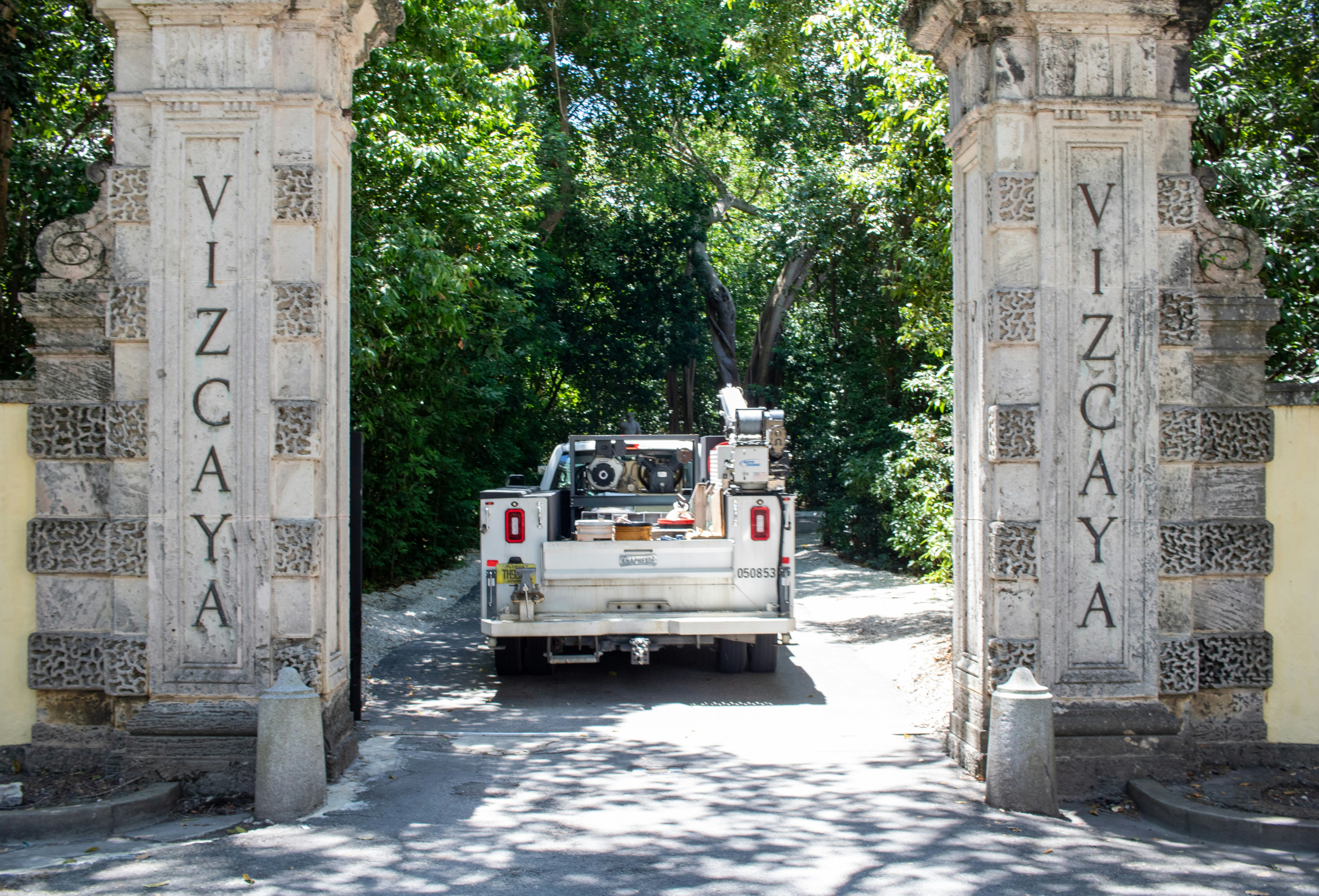 A white truck driving through a stone archway