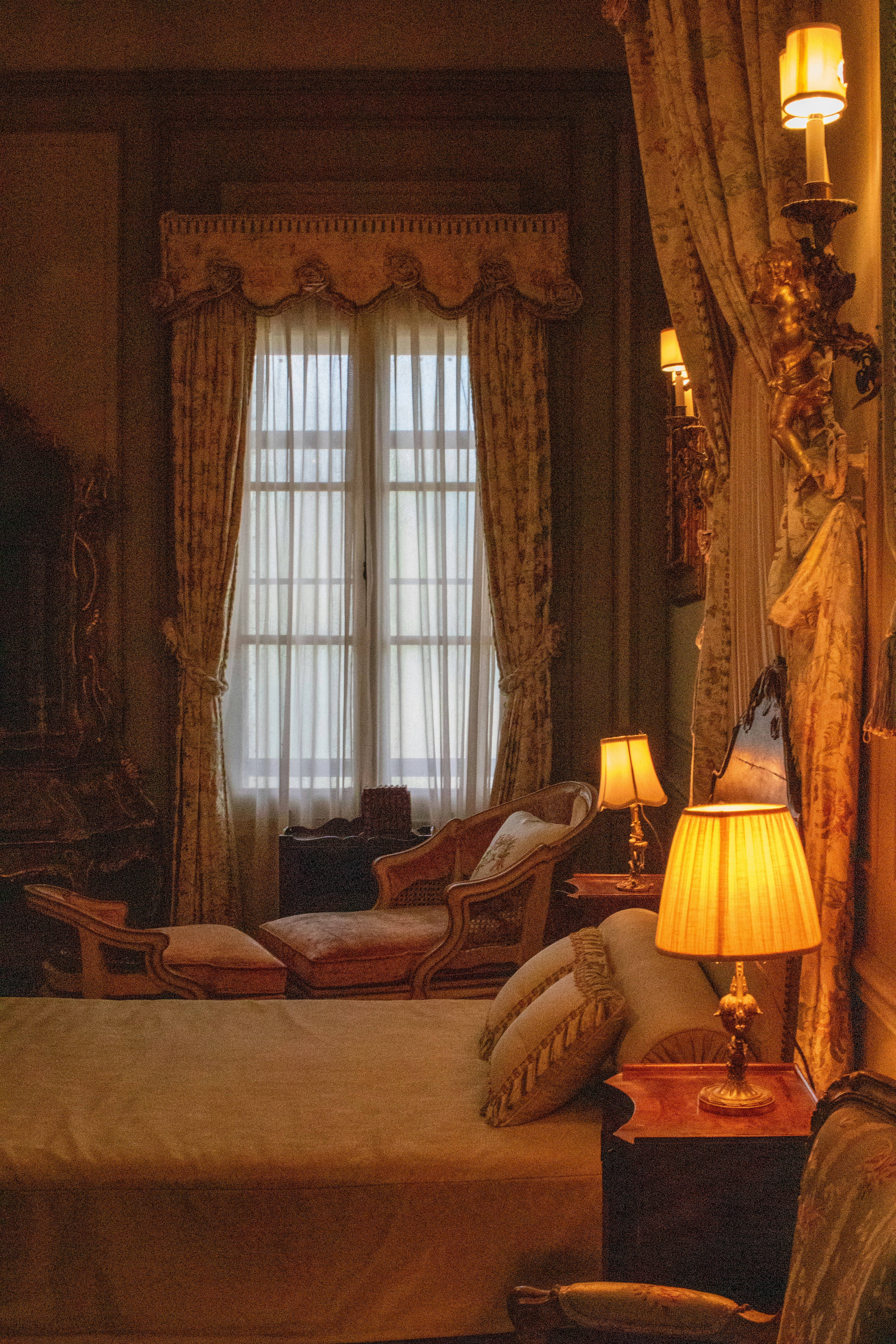 A bedroom with a large bed and two lamps