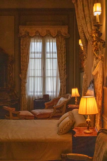 A bedroom with a large bed and two lamps