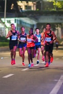 A group of people running down a street at night