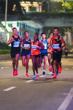 A group of people running down a street at night