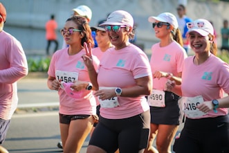 A group of women in pink shirts running in a race